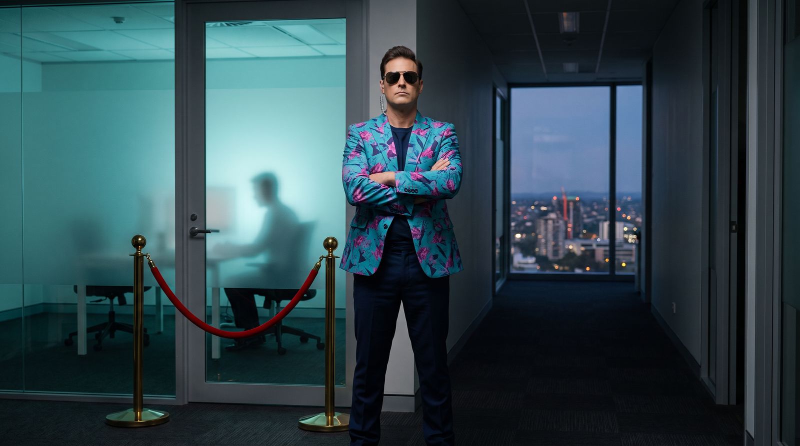 Buddy in sunglasses stands guard at a velvet rope in front of a single glowing office door