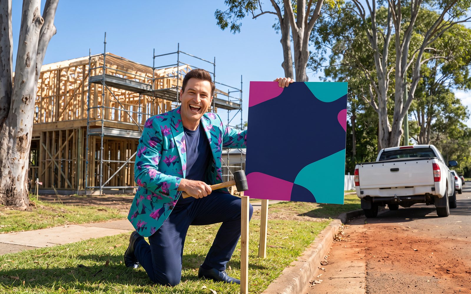 Buddy taps a new site sign into the grass in front of a house build with a mallet